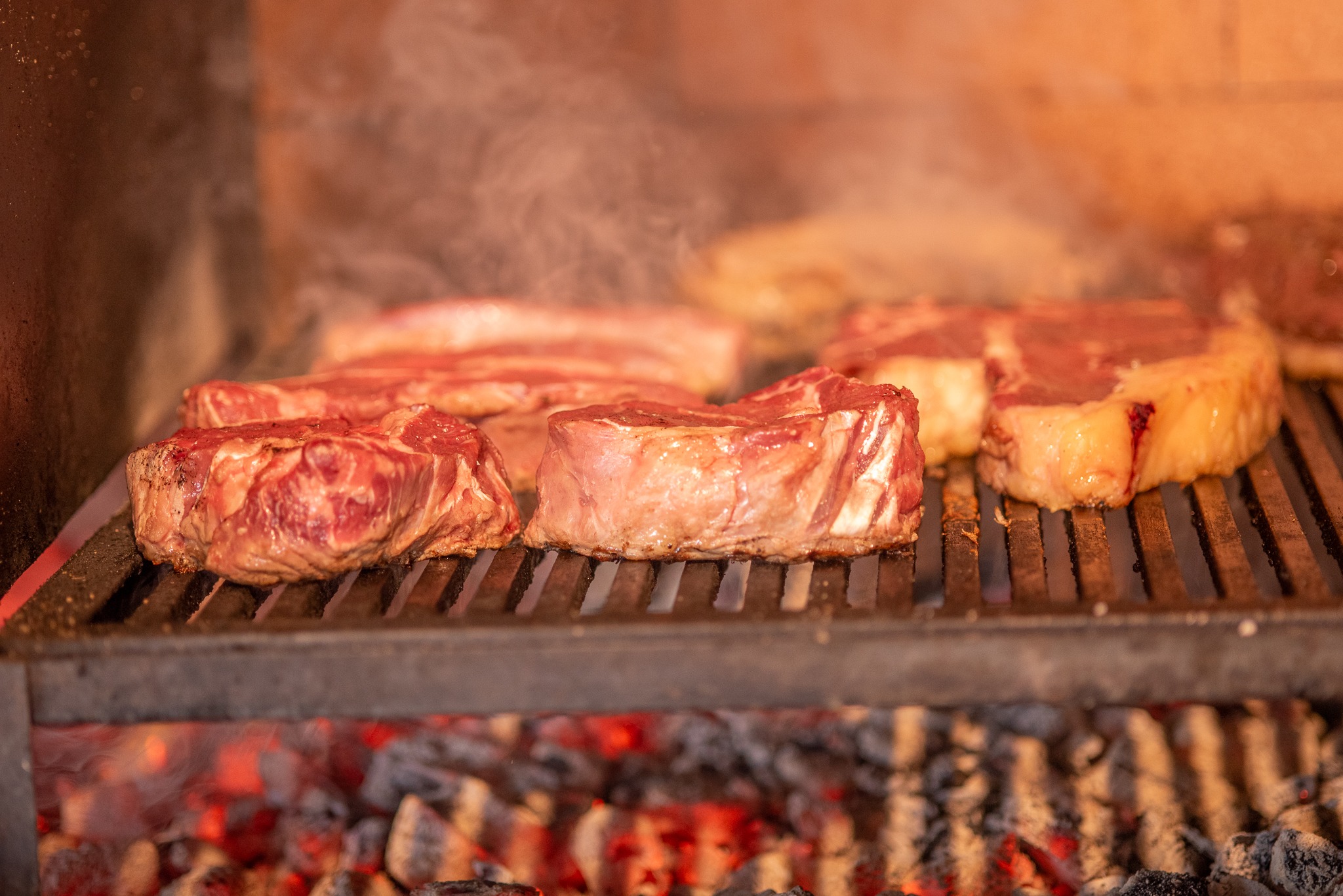 Cortes de carne na parrilla sobre brasas acesas